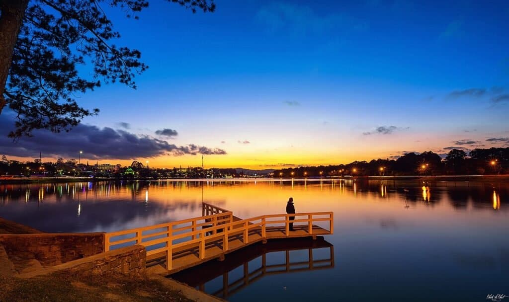 A man standing on the deck overseeing the Xuan Huong Lake in vietnam
